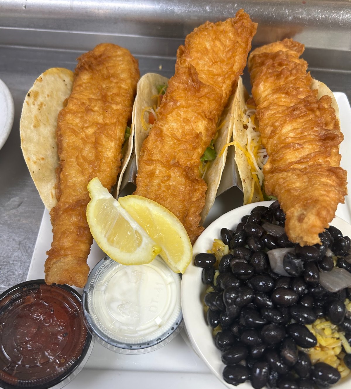 Fried fish tacos with black beans and lime
