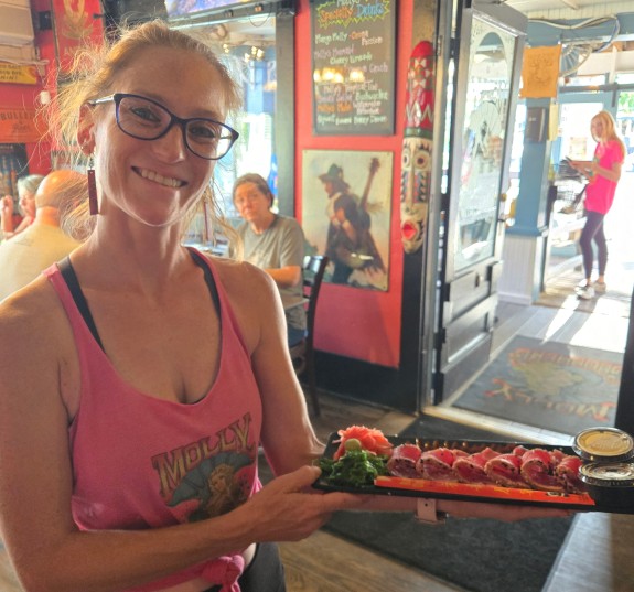 Server holding a sushi tray at Molly Goodhead's